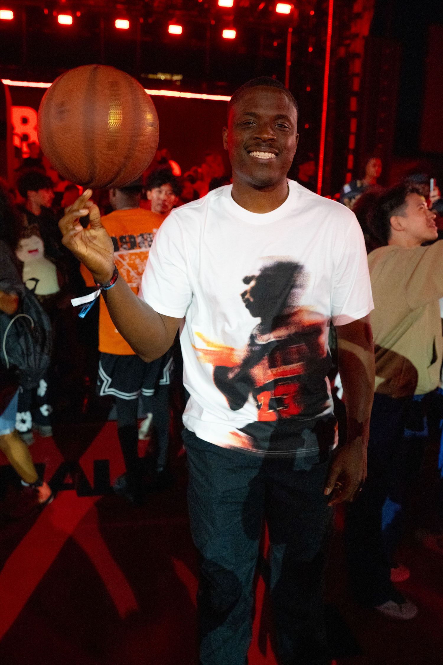 Group wearing white t-shirts dancing under red lighting at a party or club.