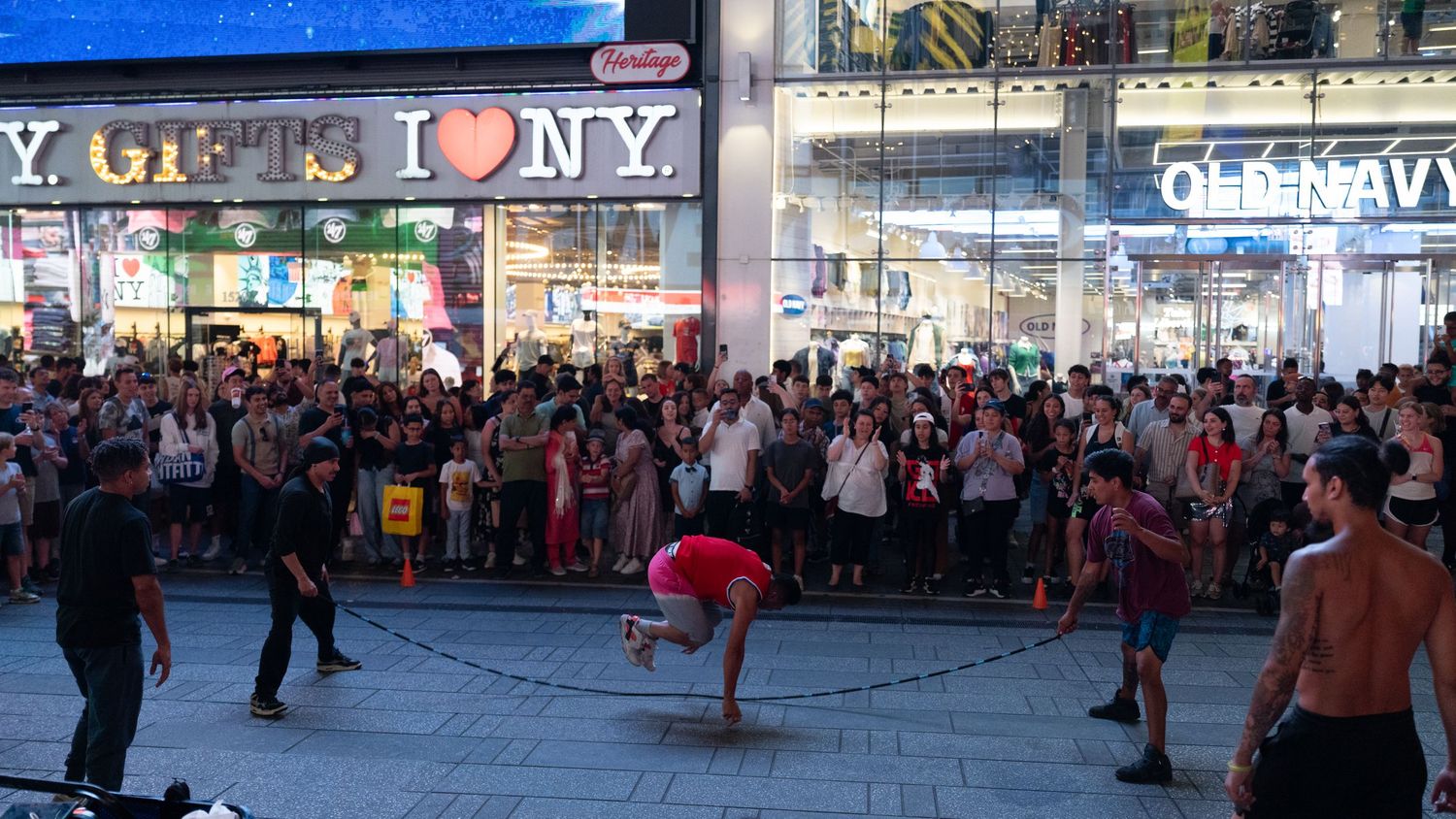 Street performance taking place in front of a crowd at Times Square.