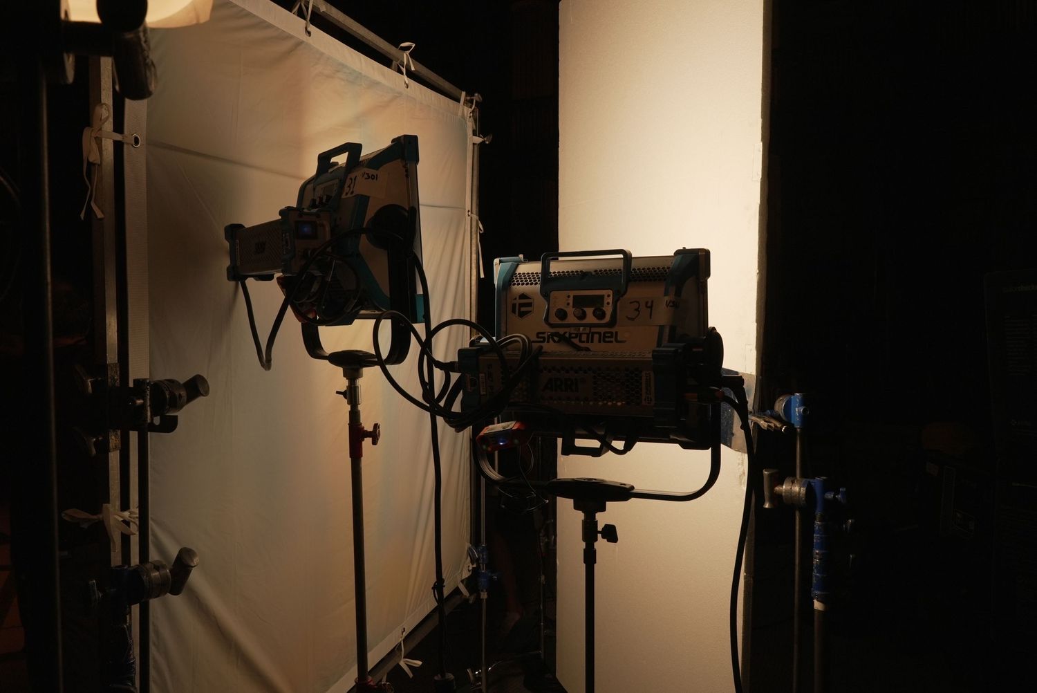 Professional lighting equipment and cameras set up in a dark studio.