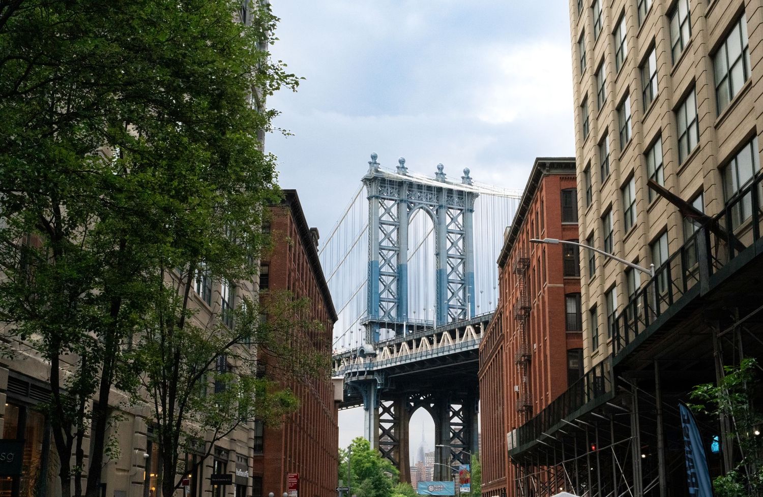 Manhattan Bridge viewed through historic brick buildings in DUMBO Brooklyn.