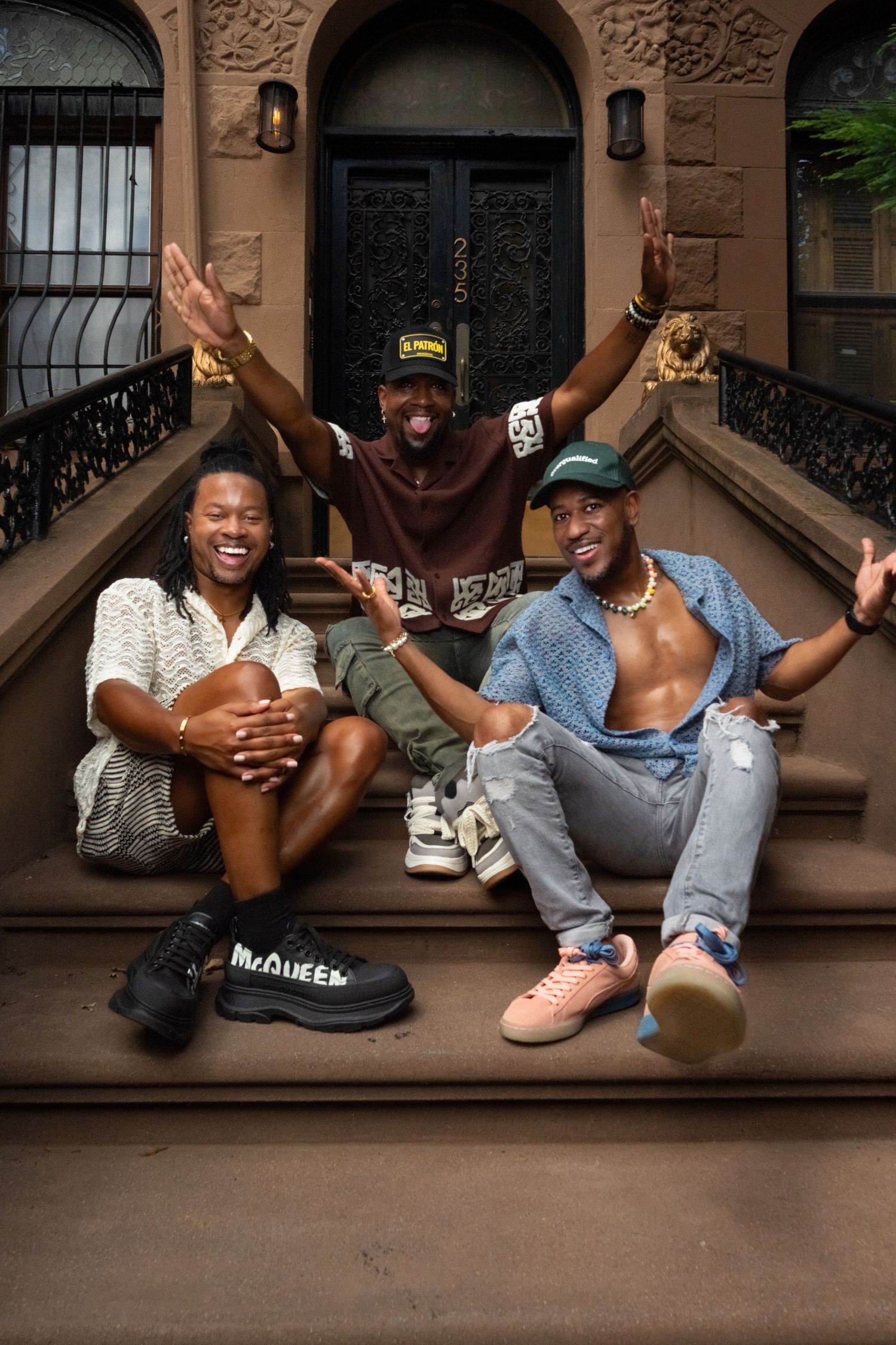 People lounging casually on brownstone steps sharing laughs and good times.