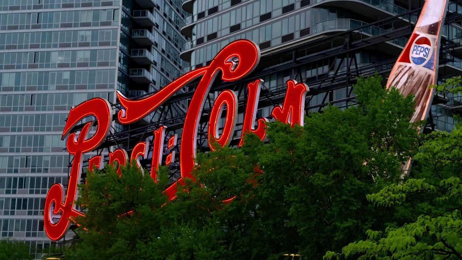Iconic red Pepsi Cola sign against a backdrop of tall apartment buildings in Long Island City.