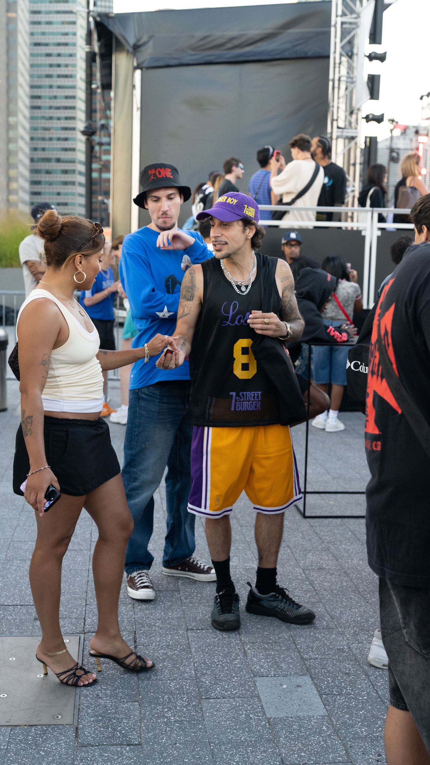 People in casual attire and sports jerseys mingling at an outdoor event space.