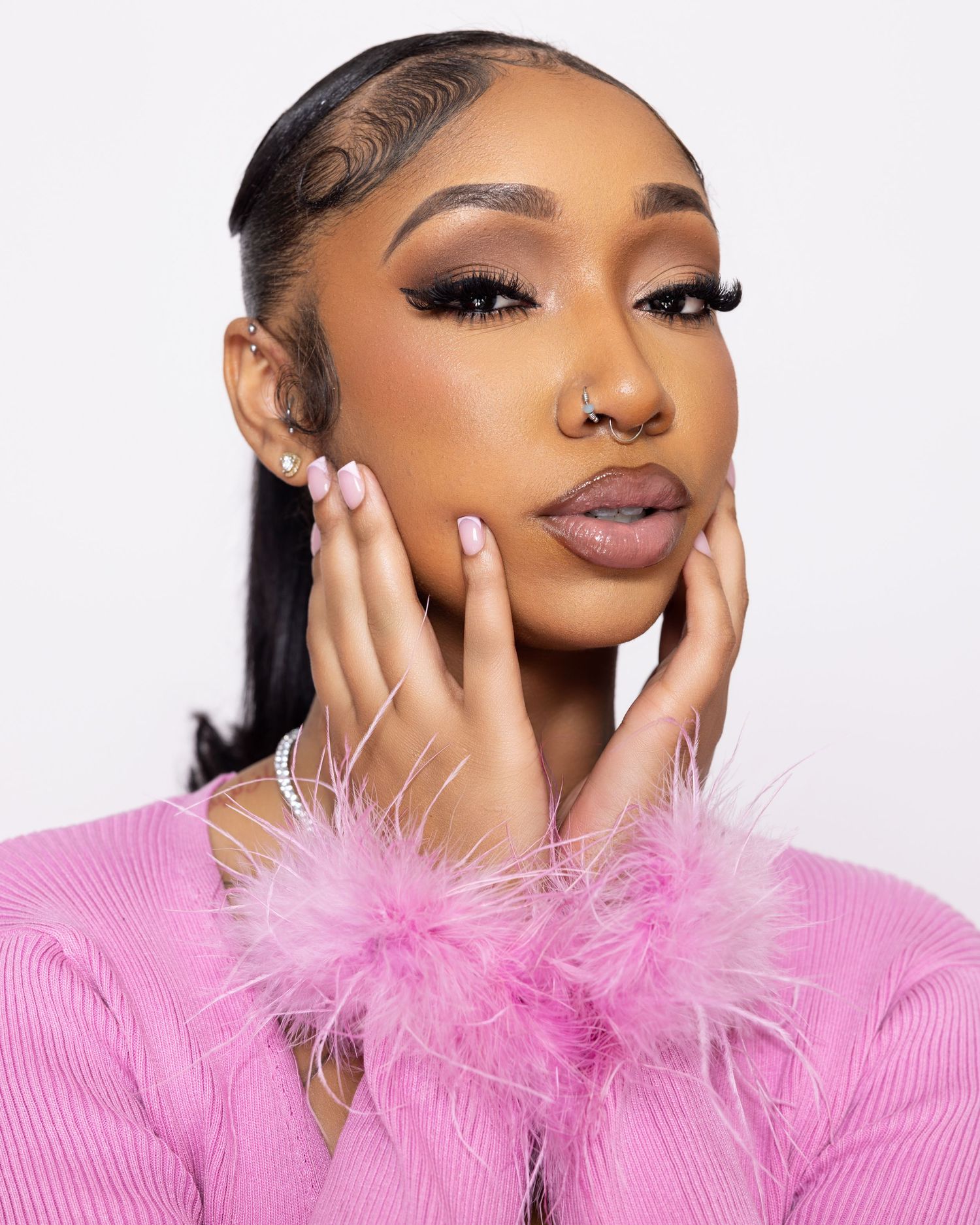 Glamour shots featuring pink feather trim and elegant makeup.