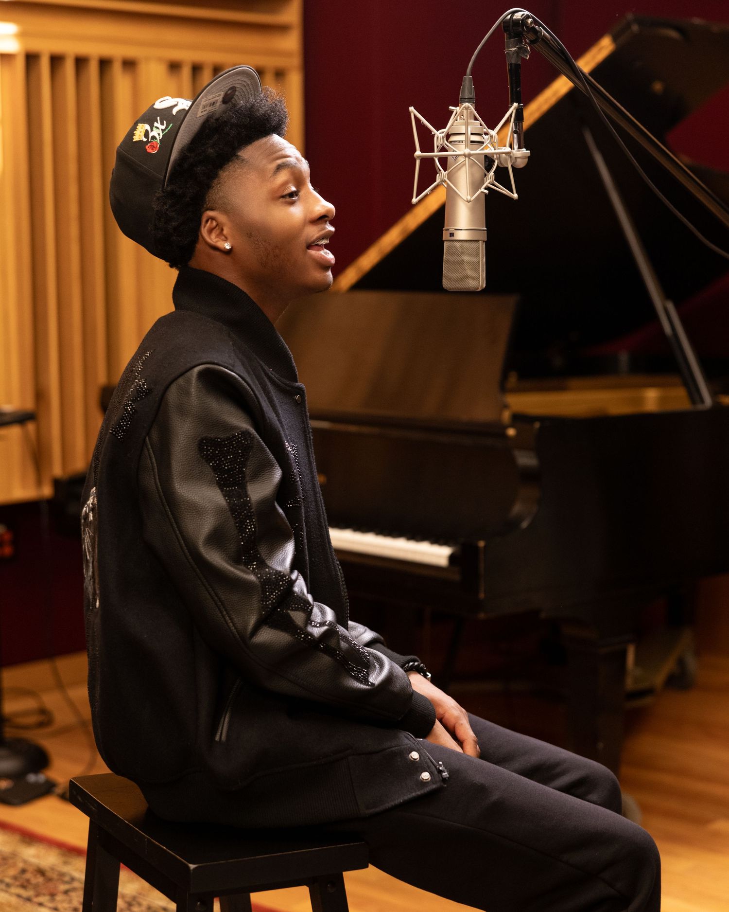 Recording studio session with piano and microphone setup in warm lighting.