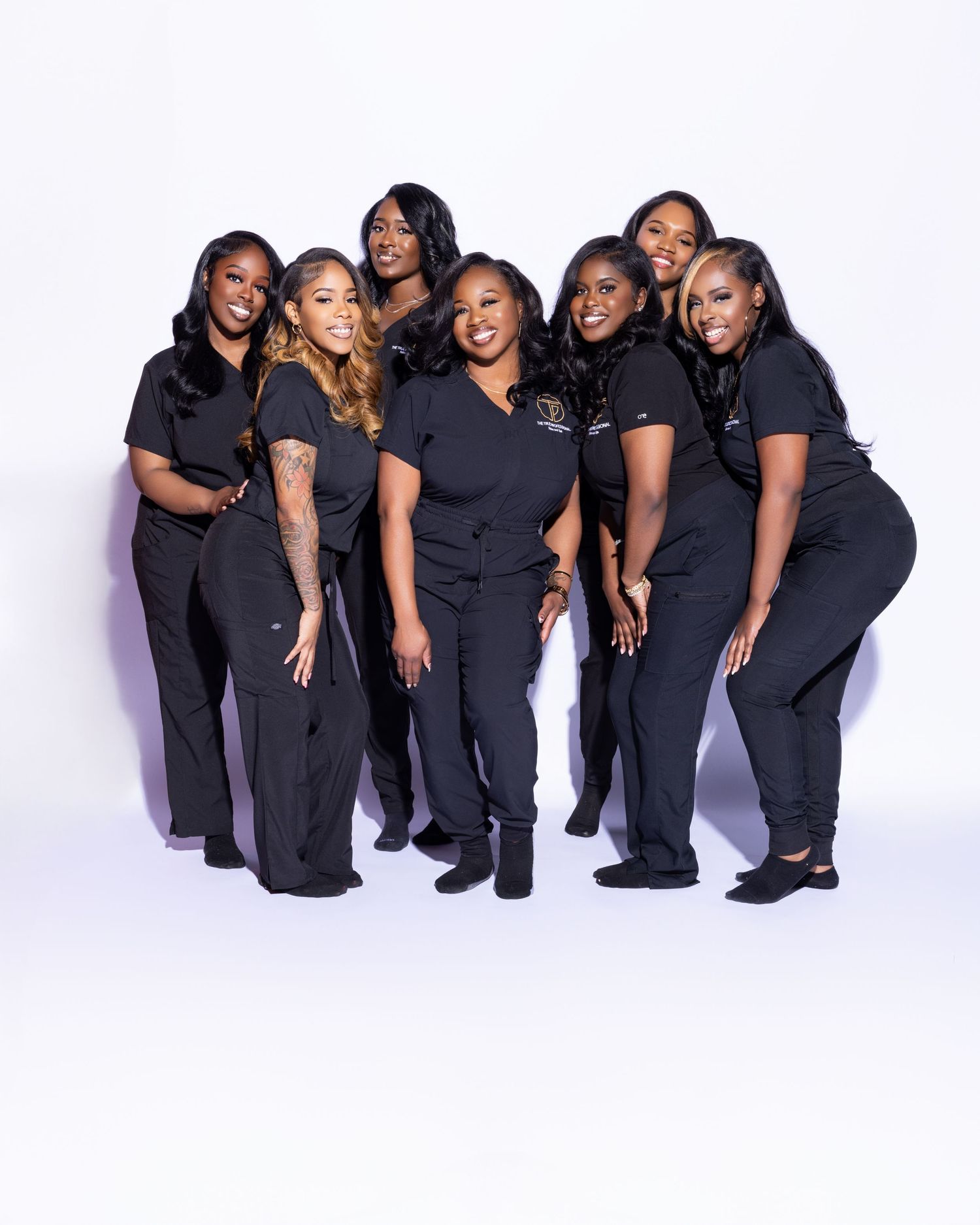 Group photo of beauty professionals wearing matching black uniforms.