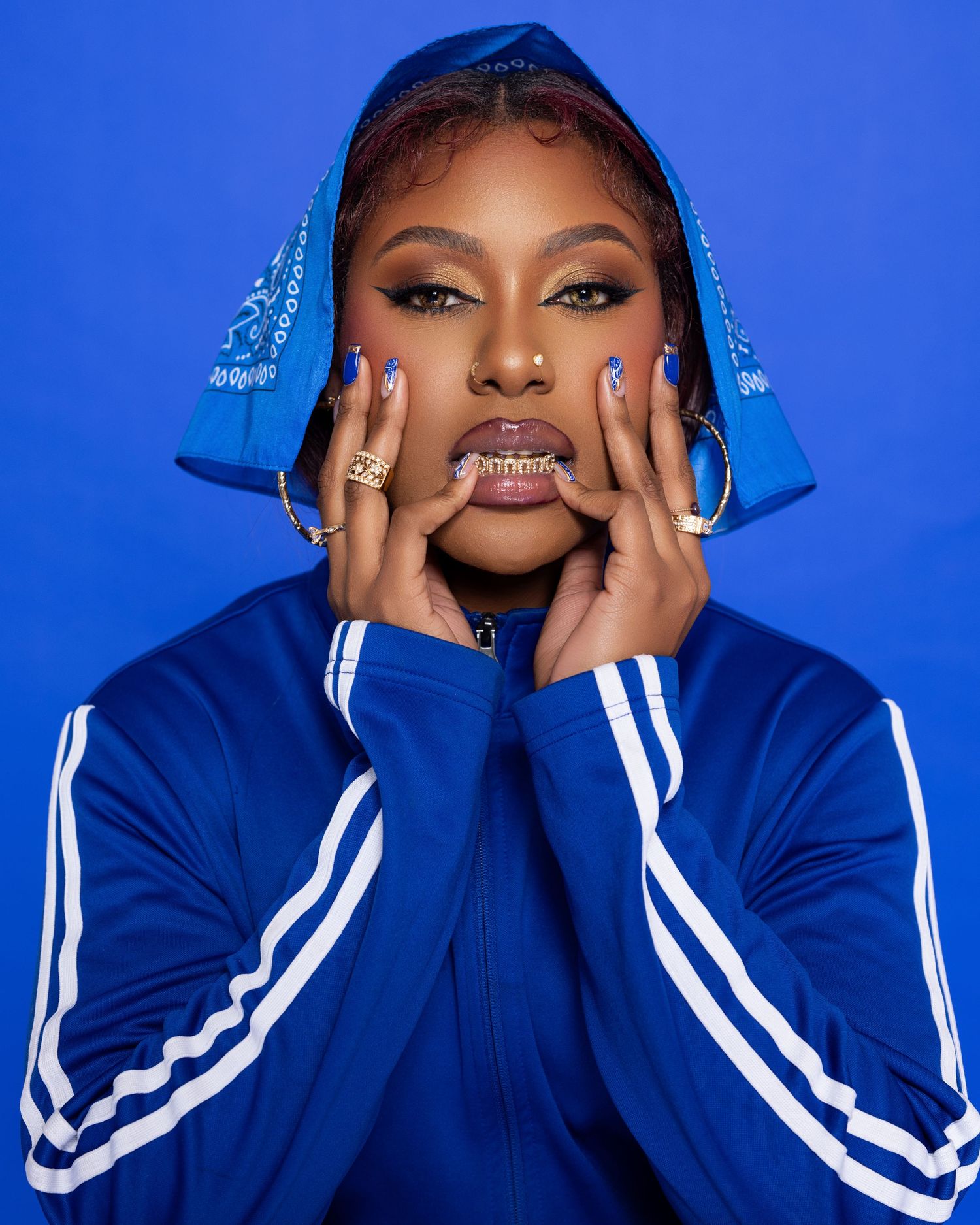 Portrait series against blue background featuring dramatic poses in navy athletic jacket.