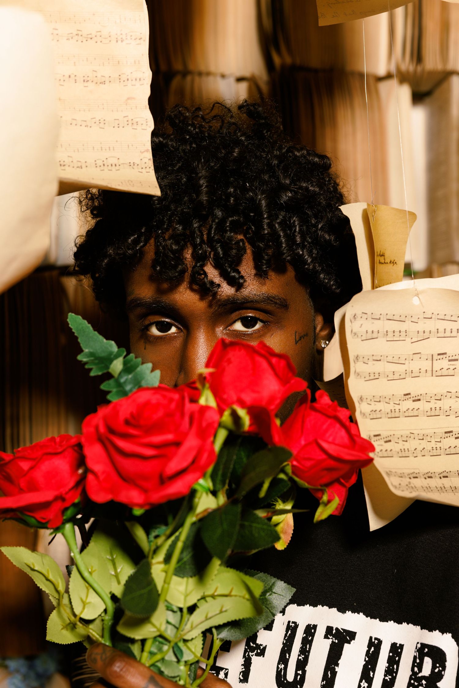 Creative portrait with red roses and sheet music creating artistic composition.