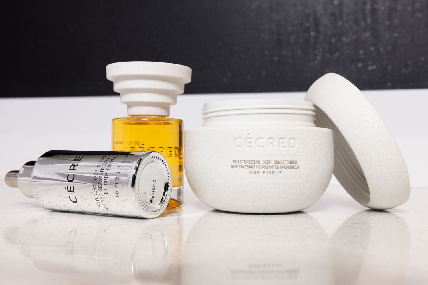 White cosmetic product containers and tools arranged on a light surface.