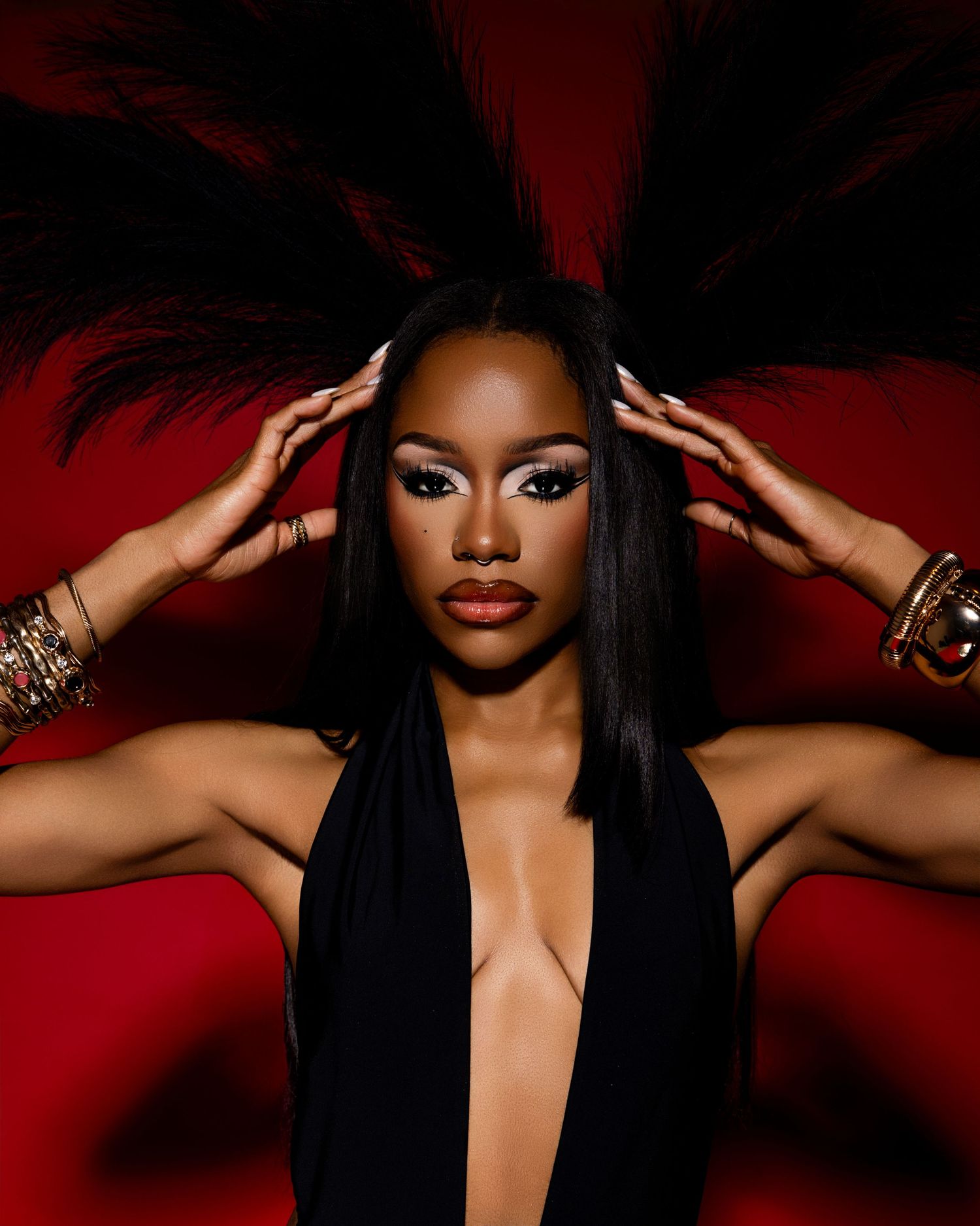 Dramatic fashion portrait series in black outfit against deep red background.