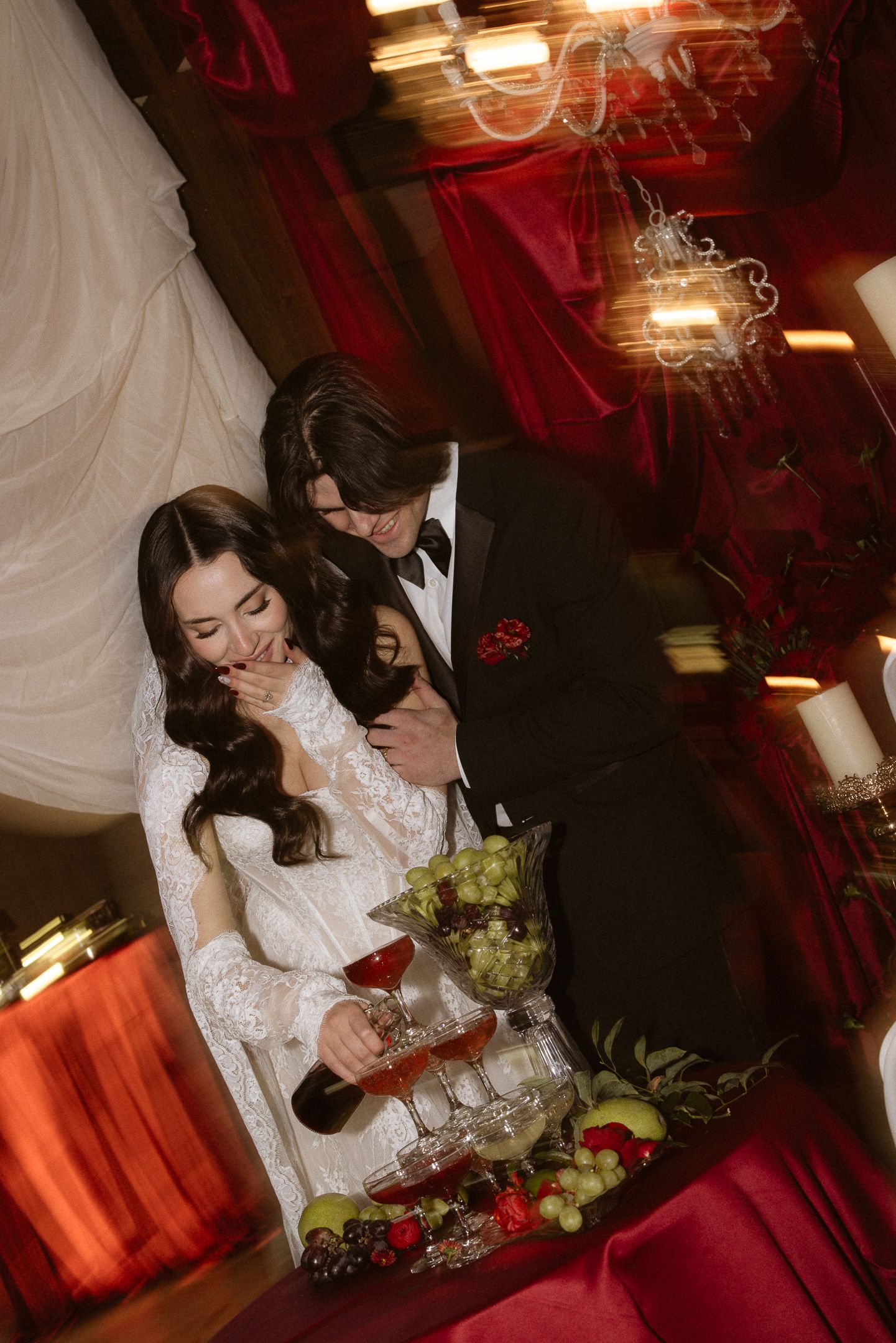 Couple embracing in candlelight among draped decor at The Lodge at Deer Meadows wedding in Utah, by Sammy Aucella Photography