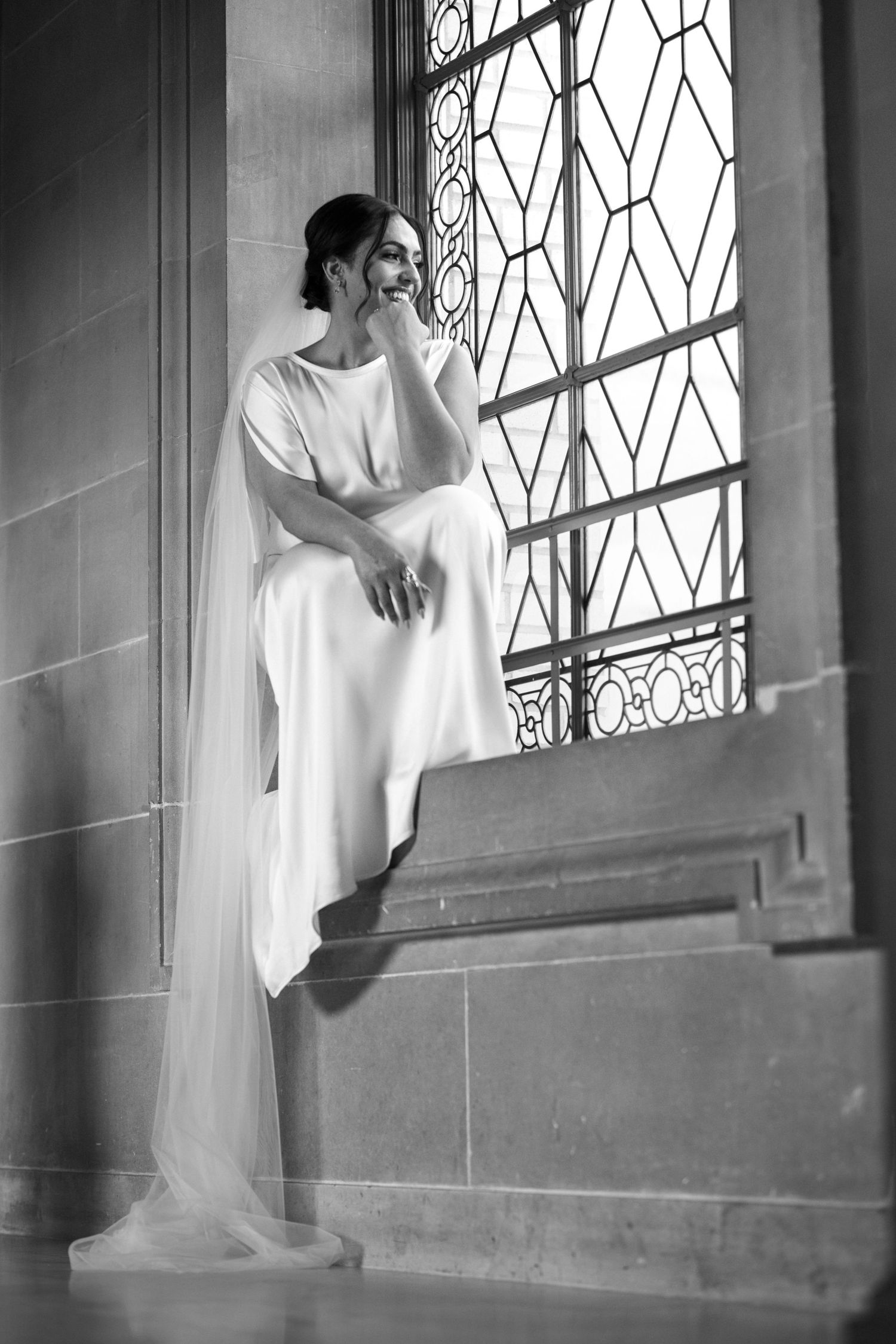 Black and white of the bride on the grand staircase at a San Francisco City Hall elopement, by Sammy Aucella Photography