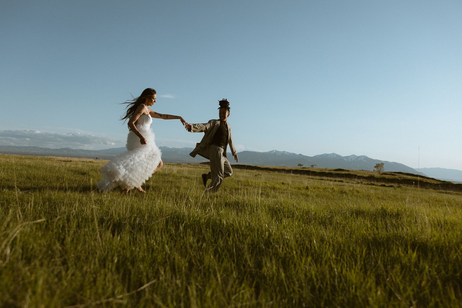 Couple dancing in a green mountain field in Utah, by Sammy Aucella Photography