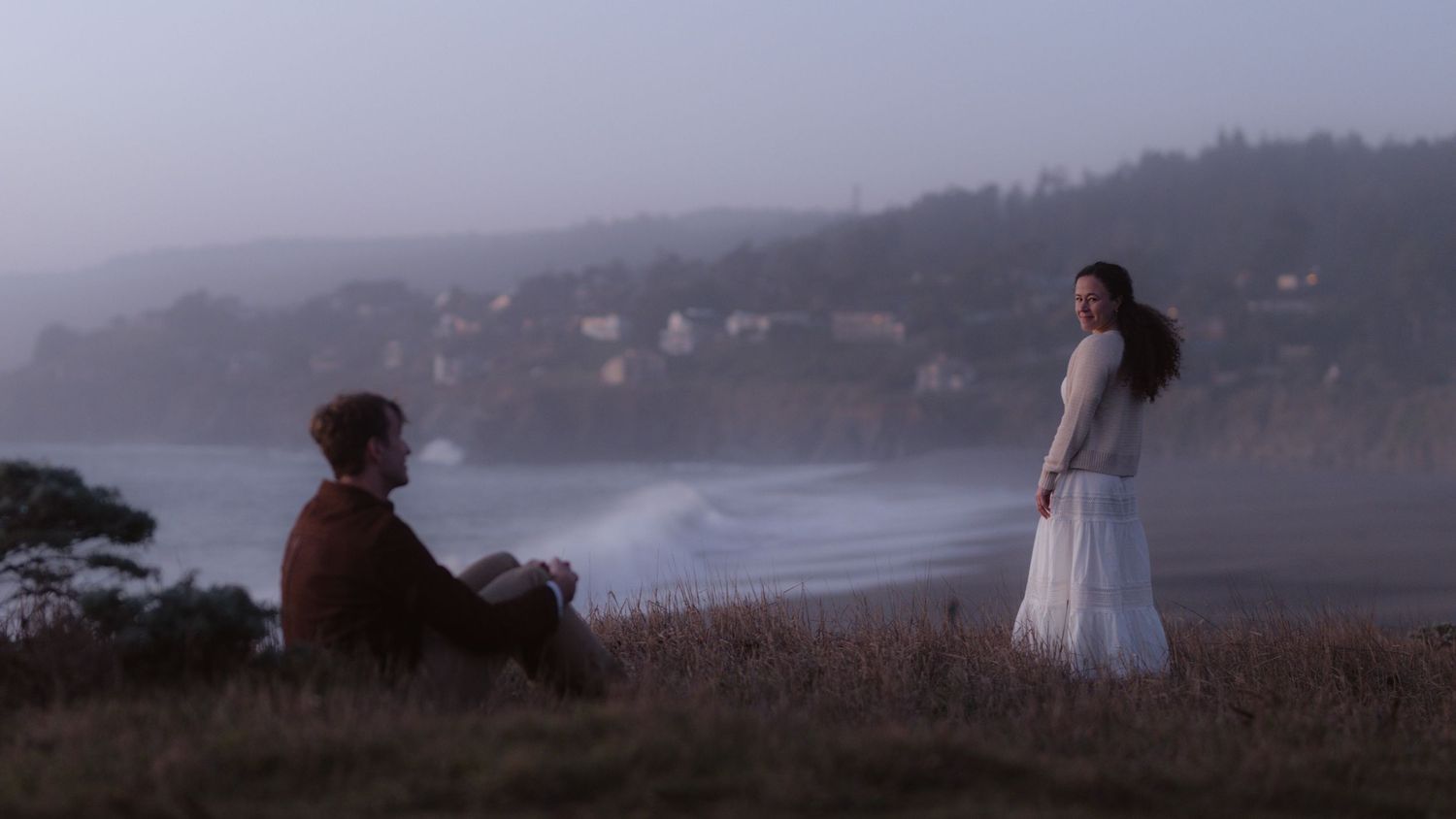 Couple sitting on rocky coastal area during engagement session in Gualala California Mendocino CA by Sammy Aucella Photography