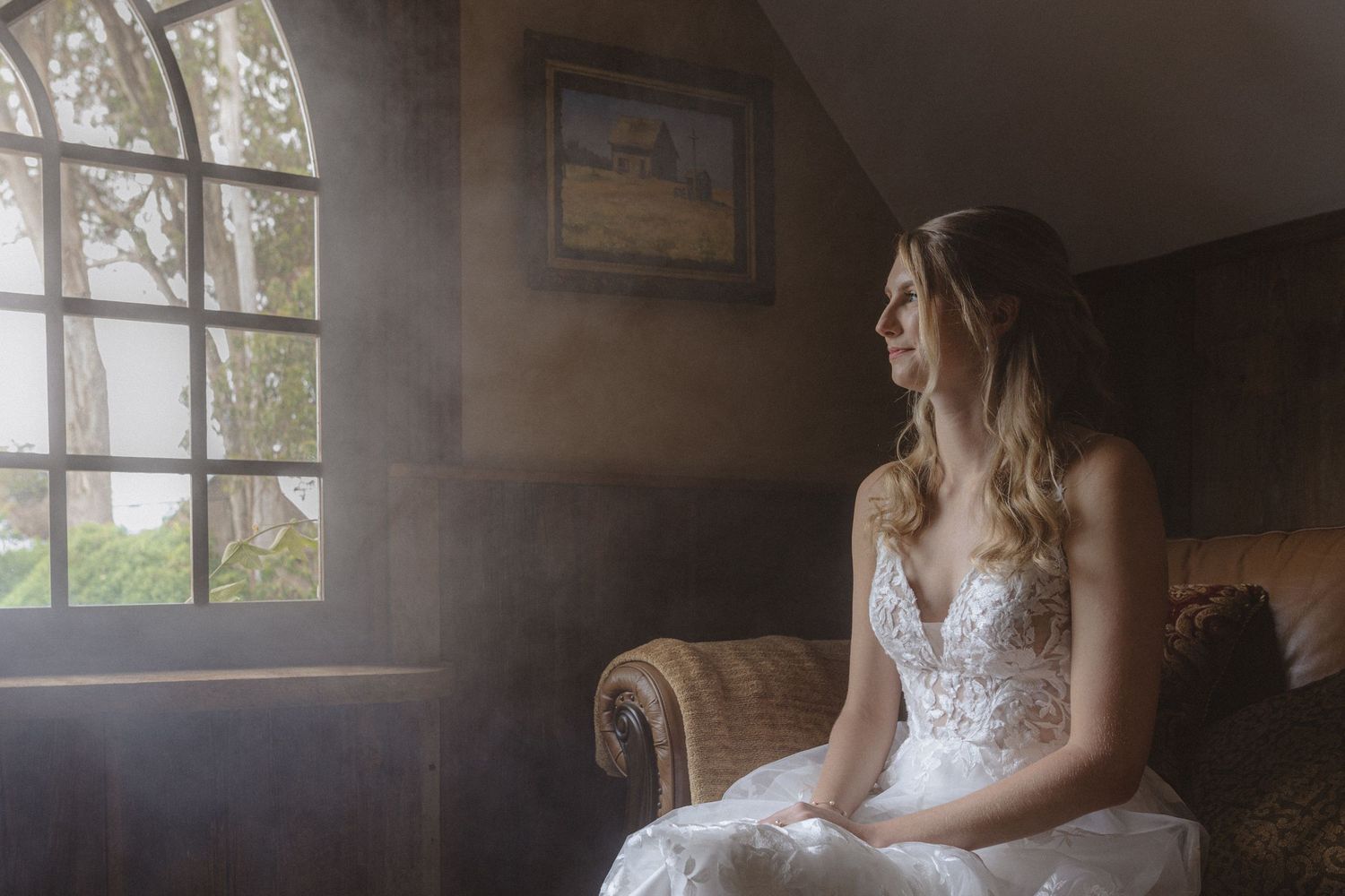 Bride seated in soft window light at a Spring Ranch luxury wedding in Mendocino, California, by Sammy Aucella Photography