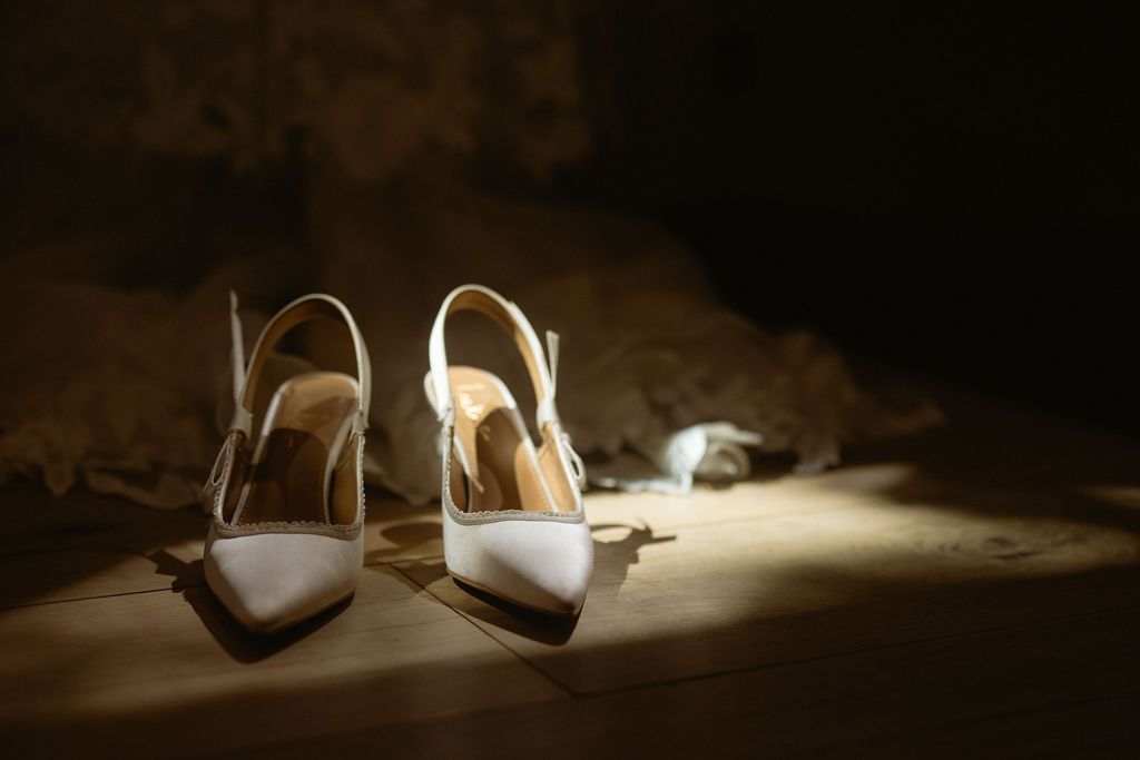 Moody cinematic detail of the bride's heels in dramatic light at a luxury wedding, by Sammy Aucella Photography