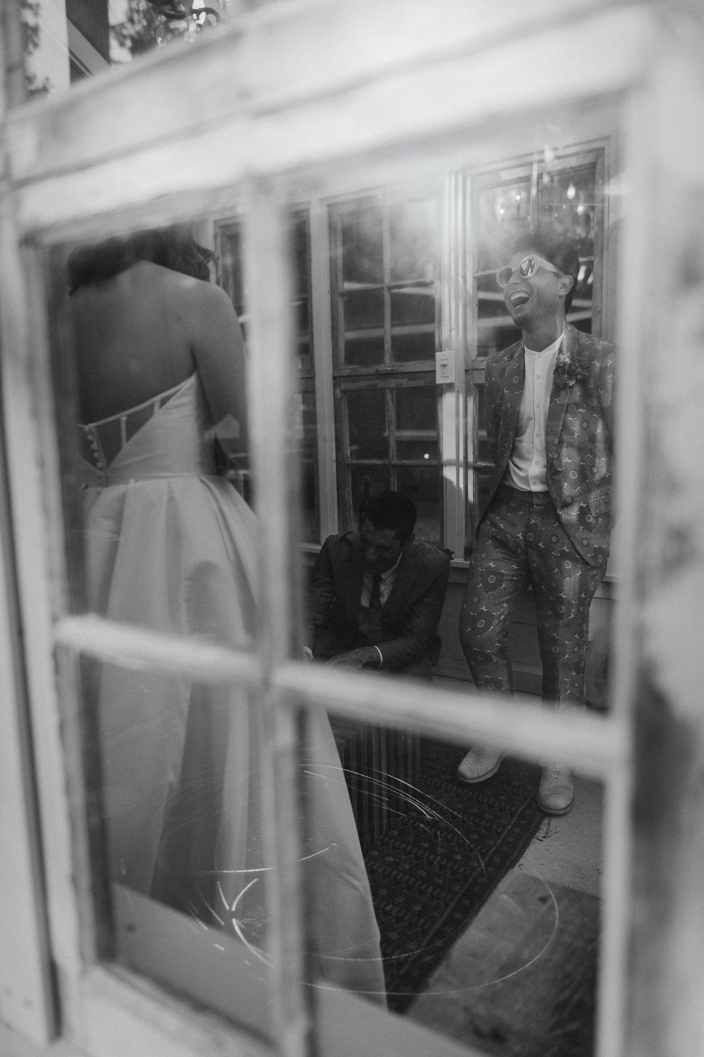 Cinematic black and white of the groom framed through a window at a Hartwood wedding in Mendocino, CA, by Sammy Aucella Photography