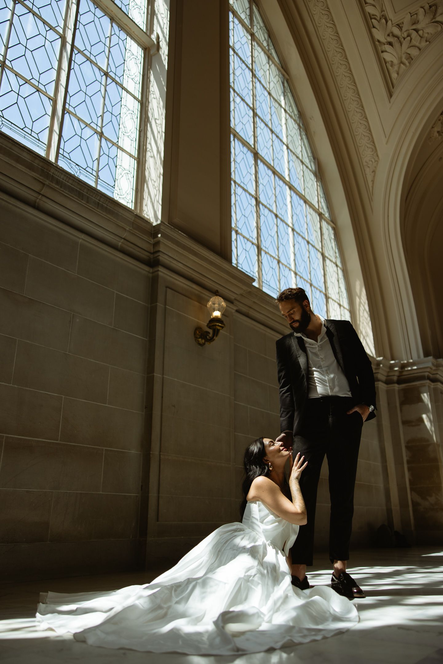 Couple by a sunlit stone window at a San Francisco City Hall elopement, by Sammy Aucella Photography