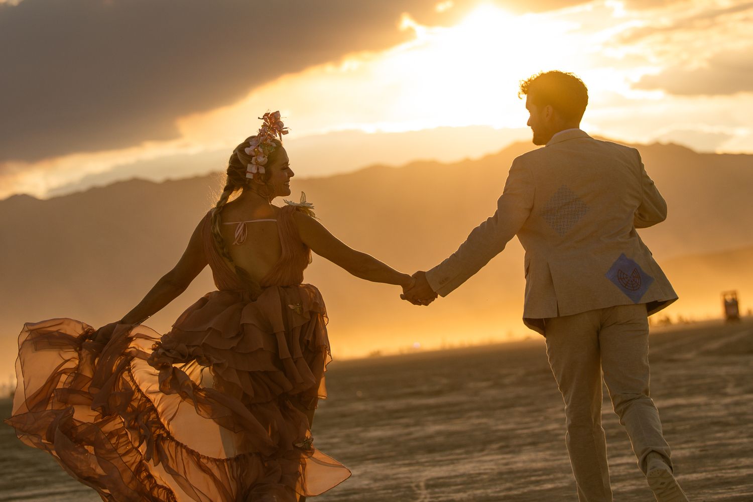 Couple holding hands at a desert sunset in Utah, by Sammy Aucella Photography