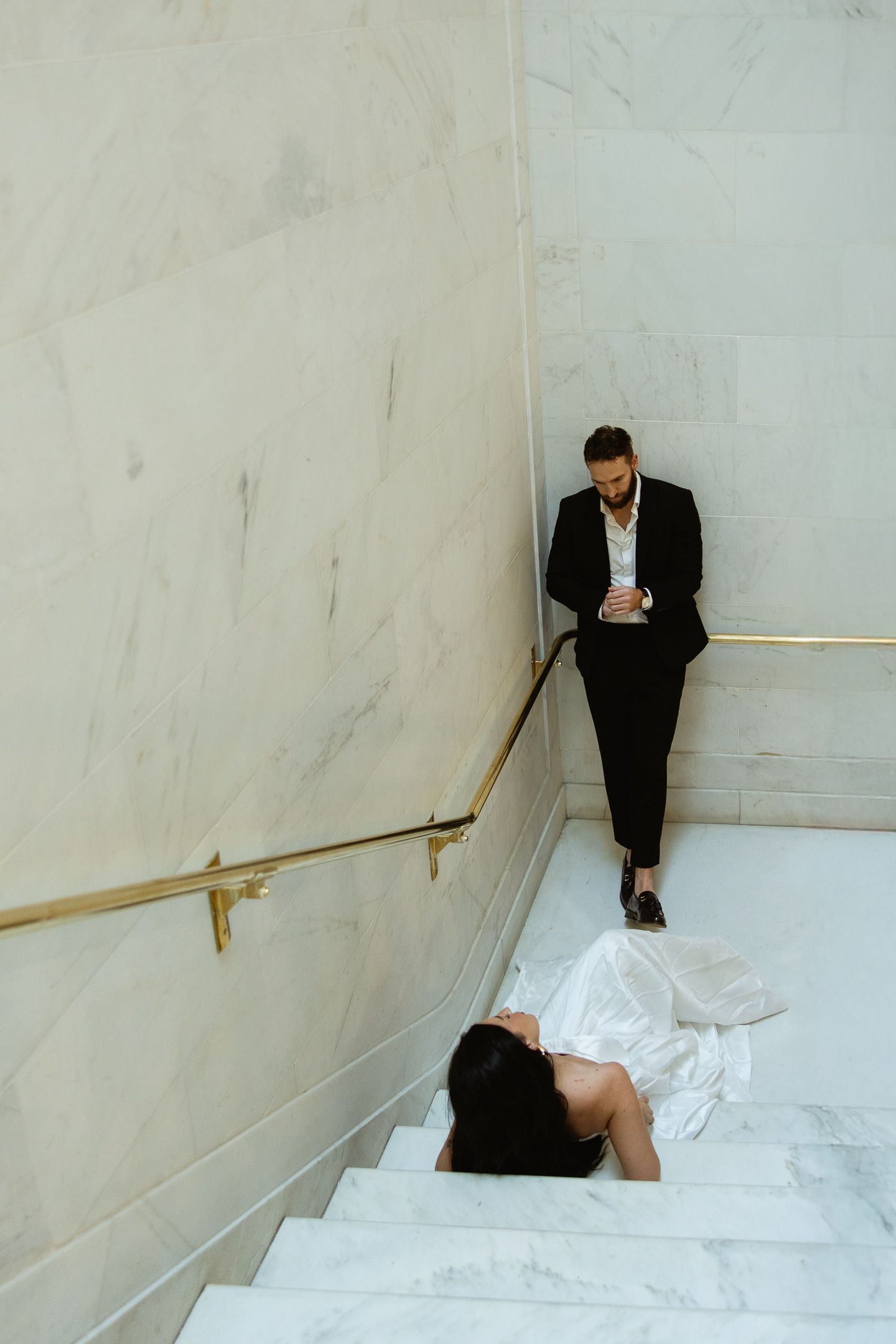 Groom seated on the marble stairs at a San Francisco City Hall elopement, by Sammy Aucella Photography