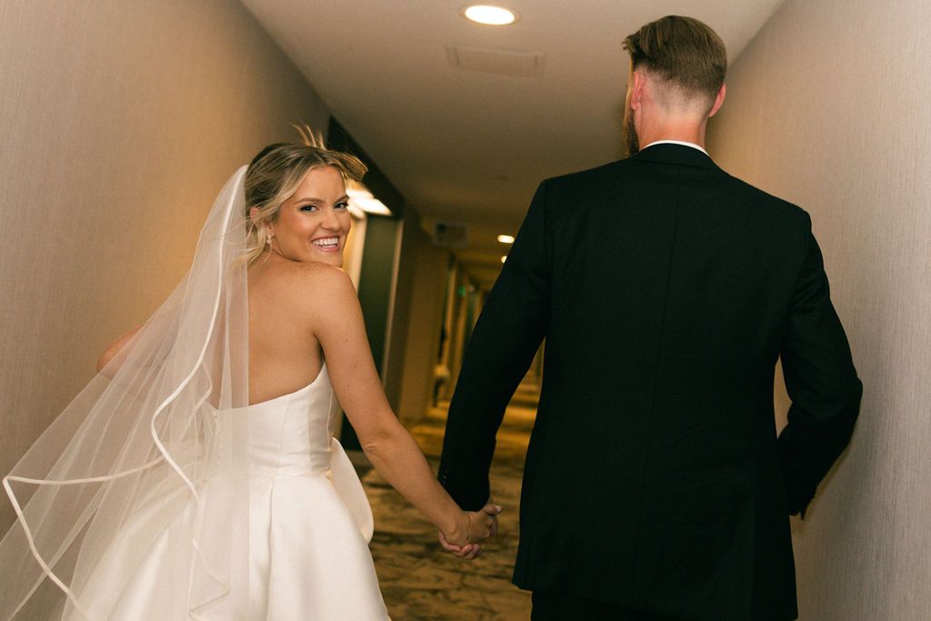 Bride and groom in a green suit walking through a Whitney Peak Hotel wedding in Reno, Nevada, by Sammy Aucella Photography