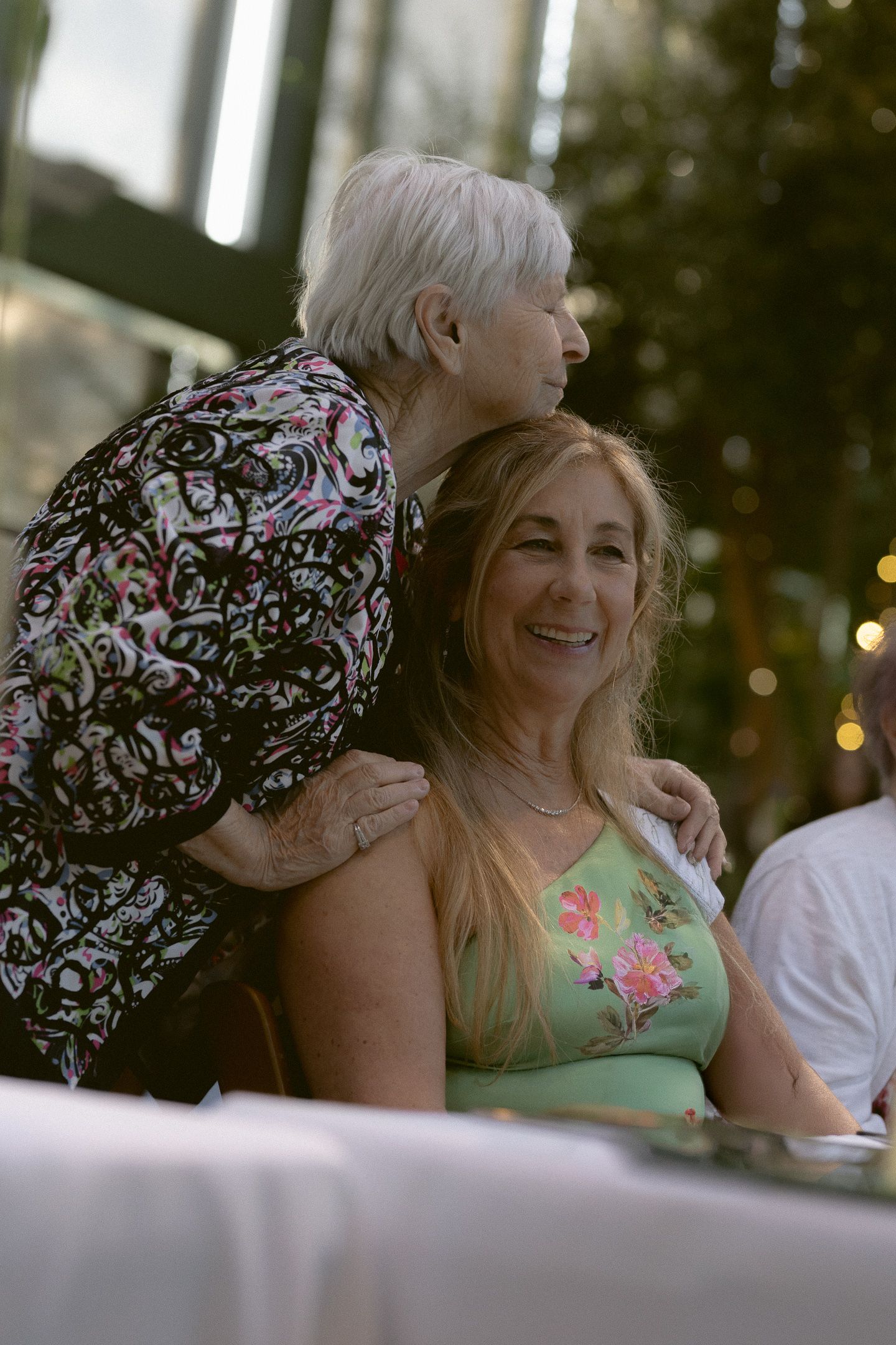 Grandmother and mother embracing at a Red Butte Garden wedding reception in Salt Lake City, Utah, by Sammy Aucella Photography