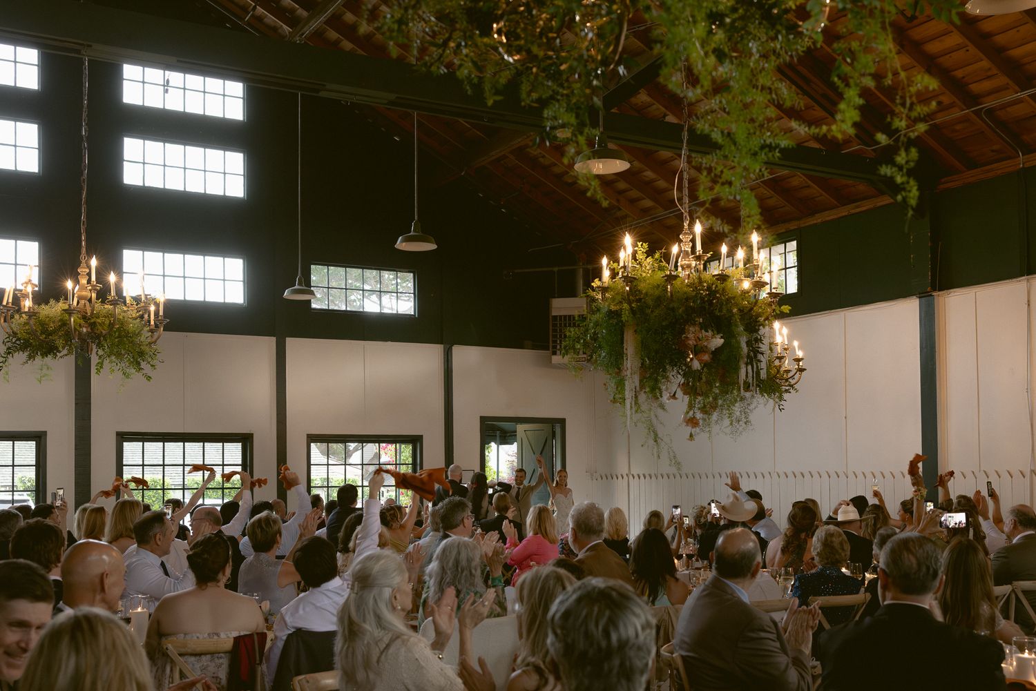 Reception under glowing chandeliers and florals at a Mission Ranch wedding in Carmel, California, by Sammy Aucella Photography