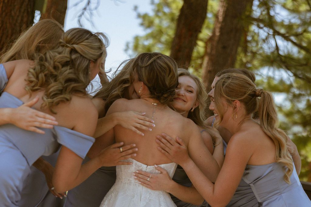 Bridesmaids in a group embrace at a Nakoma Resort wedding in Clio, California, by Sammy Aucella Photography