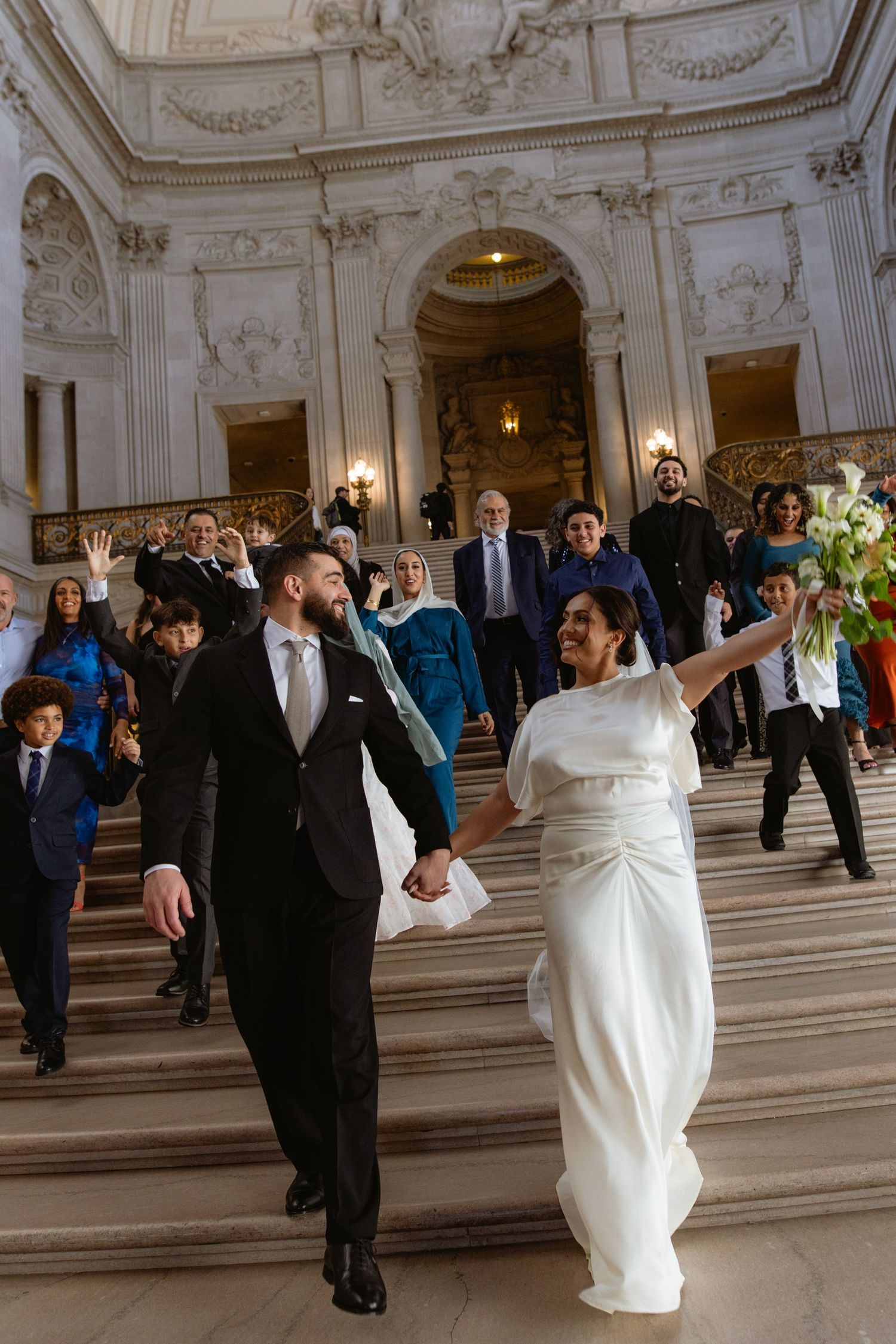 Joyful recessional with guests cheering at a San Francisco City Hall elopement, by Sammy Aucella Photography