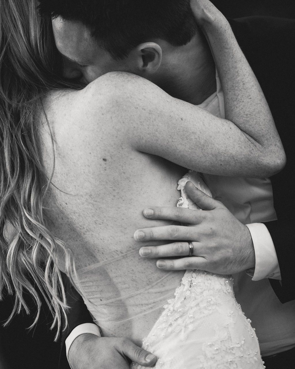 Black and white embrace with the bride's ring on the groom's back at a Ritz-Carlton Lake Tahoe wedding, by Sammy Aucella Photography