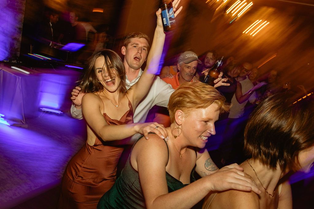 Guests dancing under colorful lights at a Whitney Peak Hotel reception in Reno, Nevada, by Sammy Aucella Photography