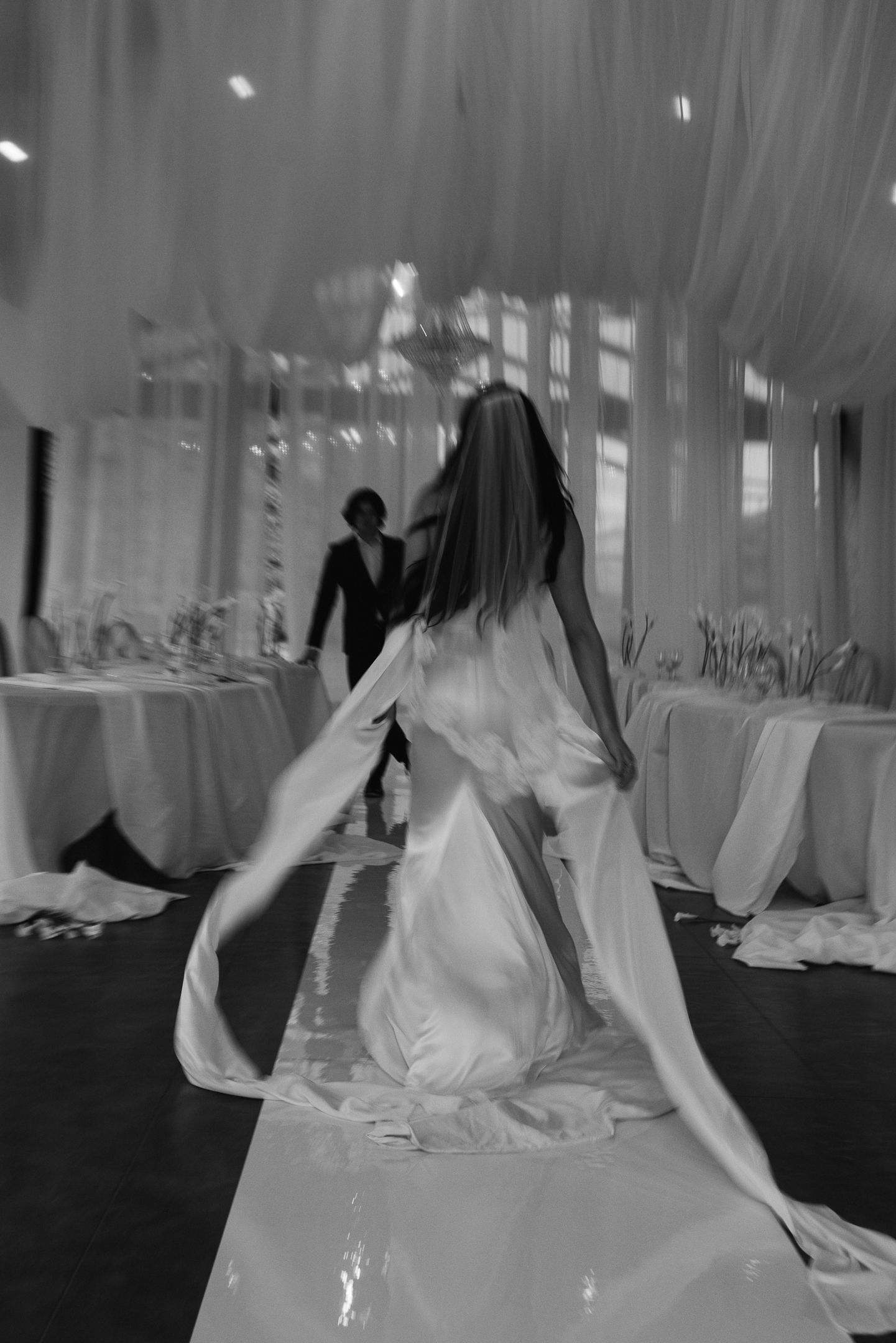 Bride walking through draped reception decor at The Red Earth Venue in Moab, Utah, by Sammy Aucella Photography