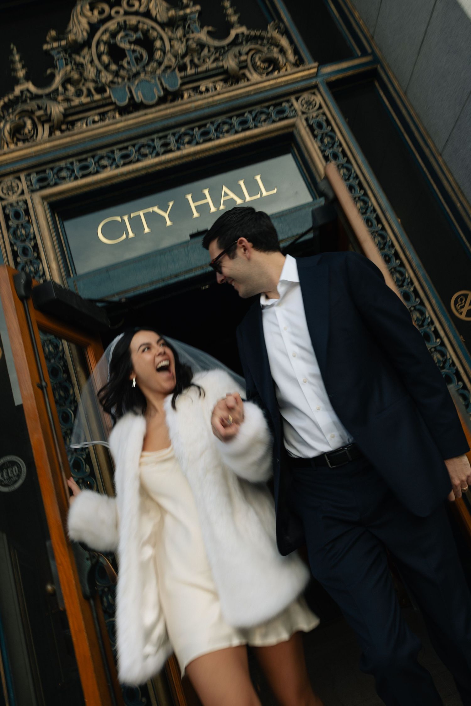 Couple celebrating at the City Hall entrance at a San Francisco elopement, by Sammy Aucella Photography