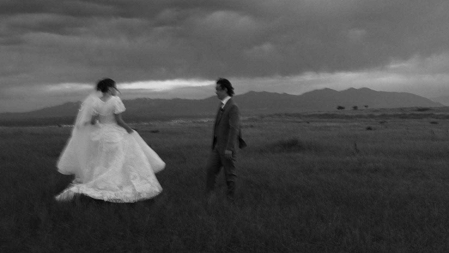 Black and white couple walking through a mountain field in Utah, by Sammy Aucella Photography