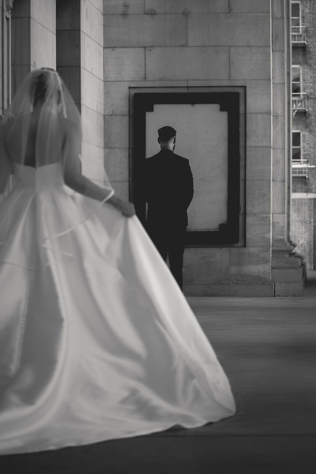 Bride passing the groom in a doorway during a first look at a Whitney Peak Hotel wedding in Reno, NV, by Sammy Aucella Photography