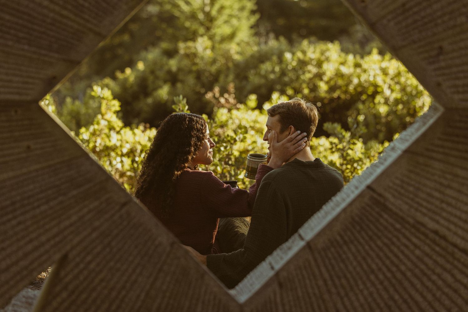 Overhead view of a couple lying together among golden autumn leaves, dreamy couples story session