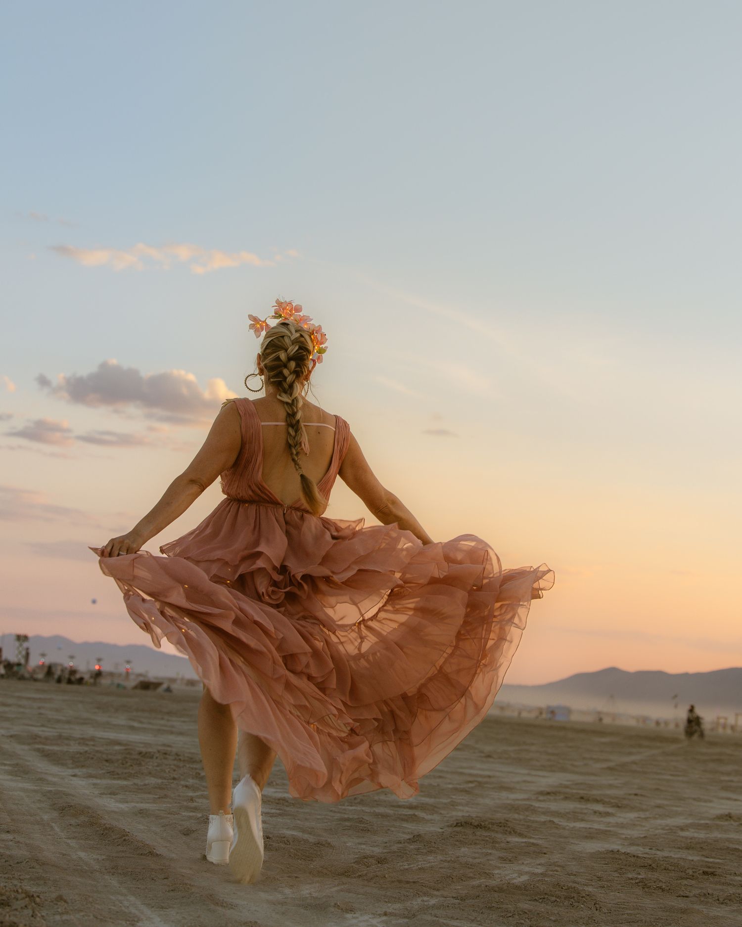 Bride in a blush gown from behind in an open field, by Sammy Aucella Photography