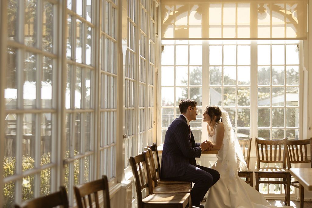Couple at a sunlit table during a MacCallum House luxury wedding in Mendocino, California, by Sammy Aucella Photography