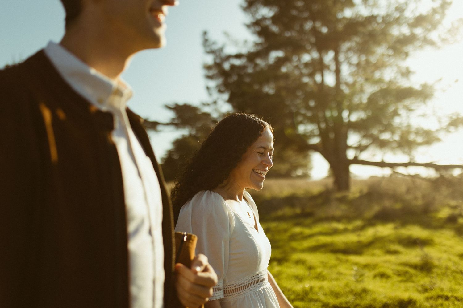 Couple walking together in field near coastal cliffs during romantic engagement session in Gualala California Mendocino CA by Sammy Aucella