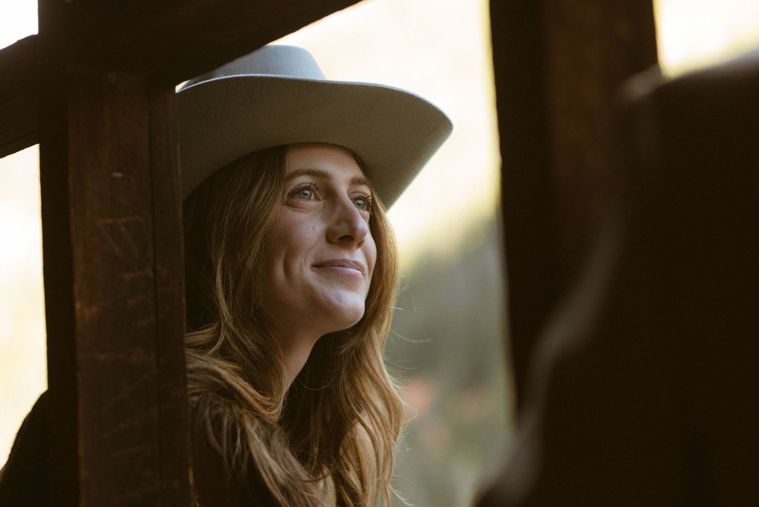 Woman in custom hat and fringe vintage western jacket at Ashcroft Ghost Town Aspen Colorado engagement session by Sammy Aucella Photography