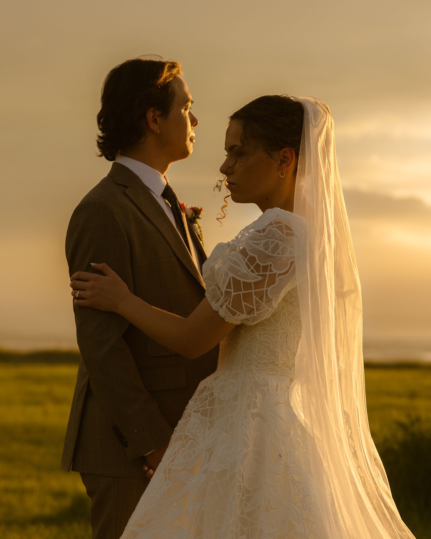 Couple embracing in a golden field at sunset in Utah, by Sammy Aucella Photography