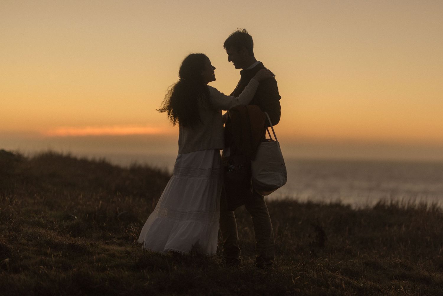 Couple walking together at golden sunset on beach during engagement session in Gualala California Mendocino CA by Sammy Aucella Photography