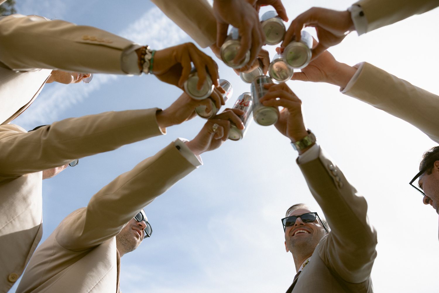 Groomsmen toasting beers while getting ready at a Mission Ranch wedding in Carmel, California, by Sammy Aucella Photography