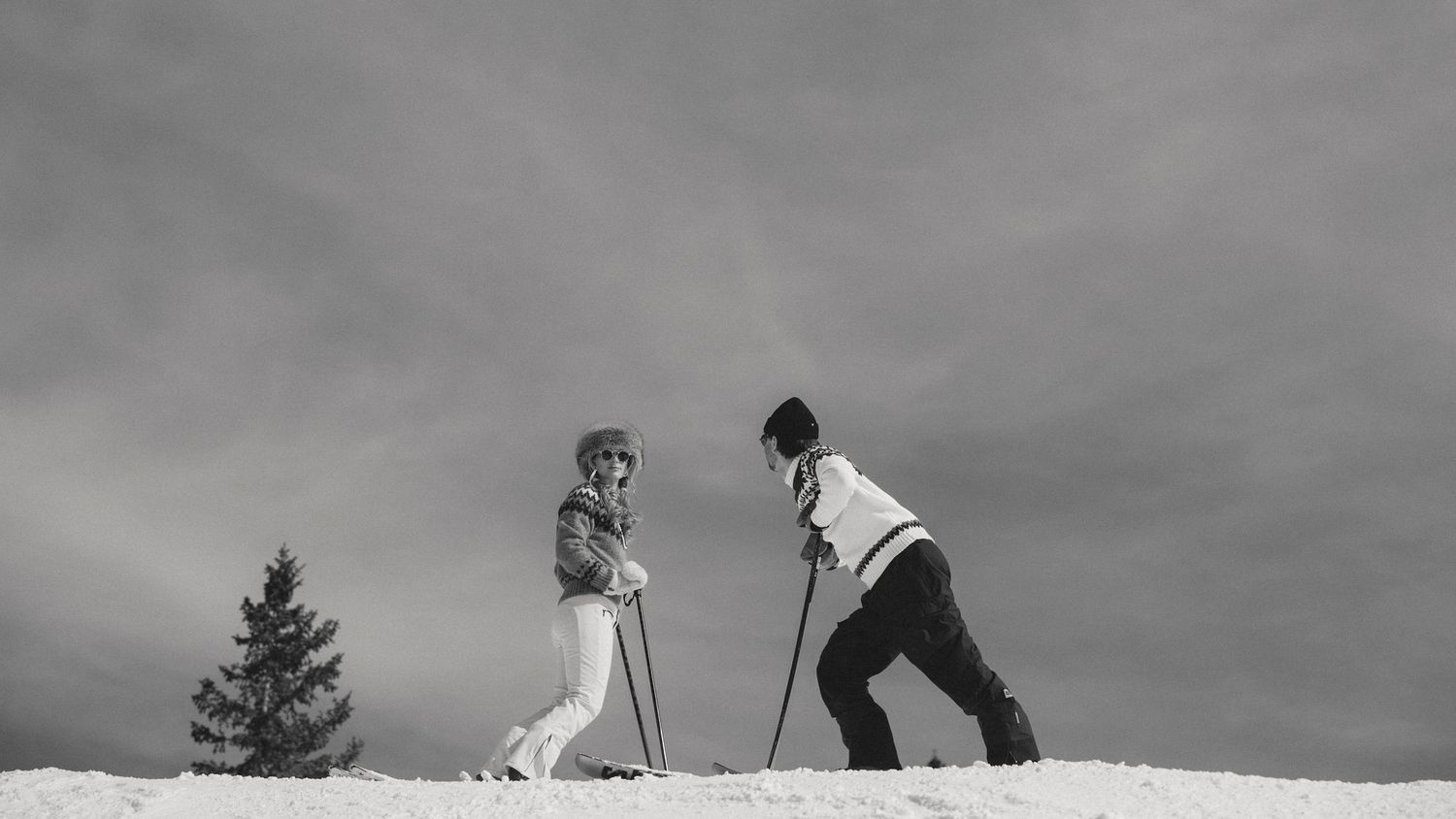 Vintage black and white film-style photo of couple skiing in Aspen Colorado during styled engagement session by Sammy Aucella Photography