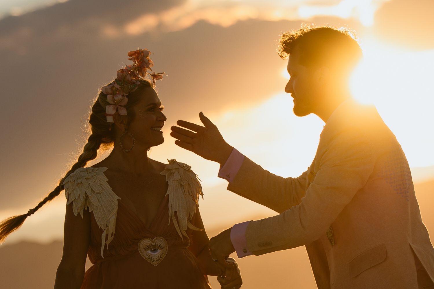 Couple silhouetted at sunset as the groom touches her face, by Sammy Aucella Photography
