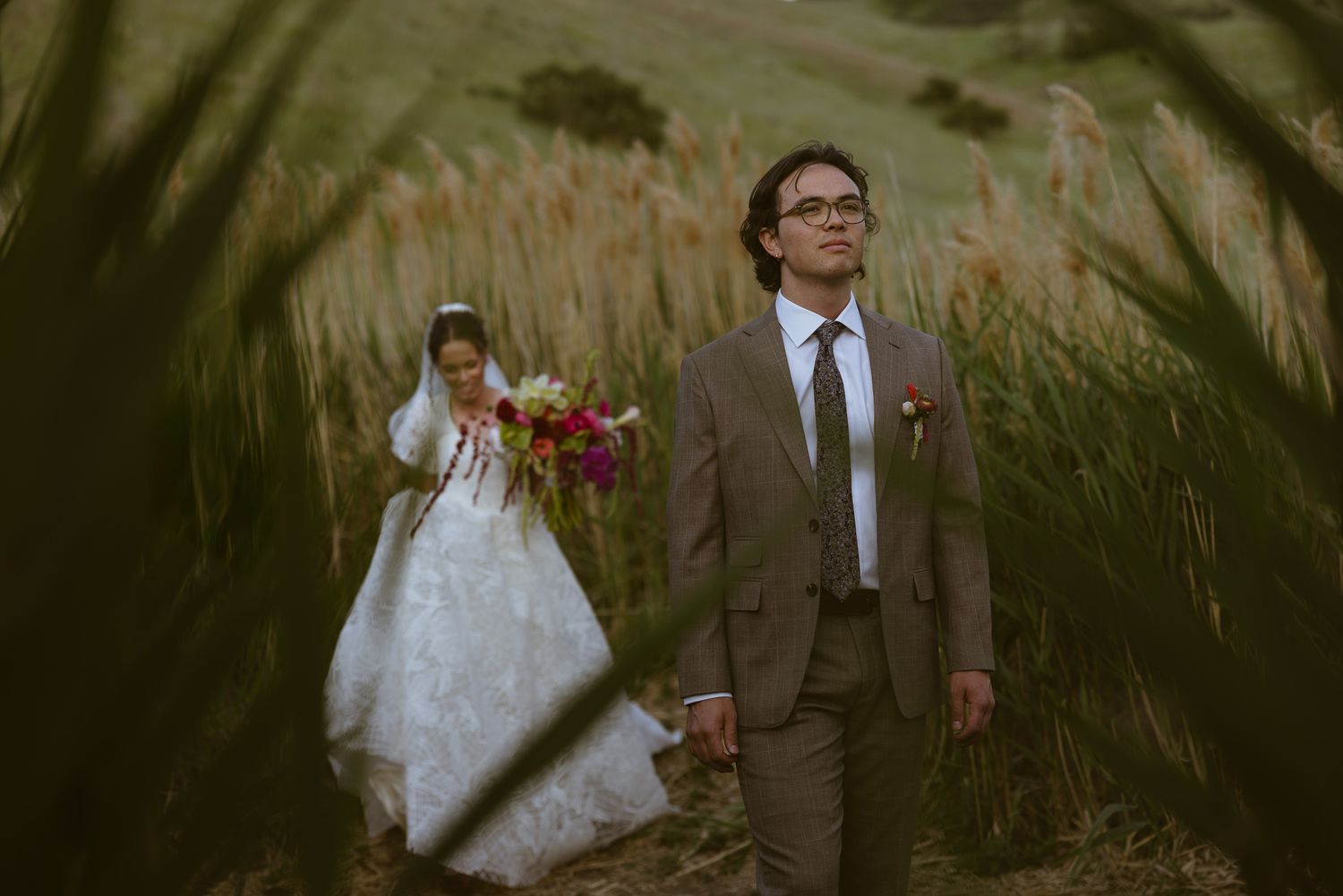 Groom and bride sharing a moment in tall grass, by Sammy Aucella Photography
