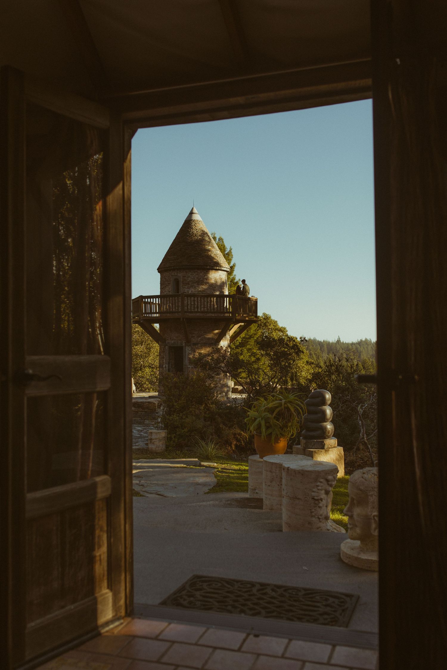View through an open doorway to a historic turreted coastal inn at golden hour, scenic Mendocino wedding venue photography