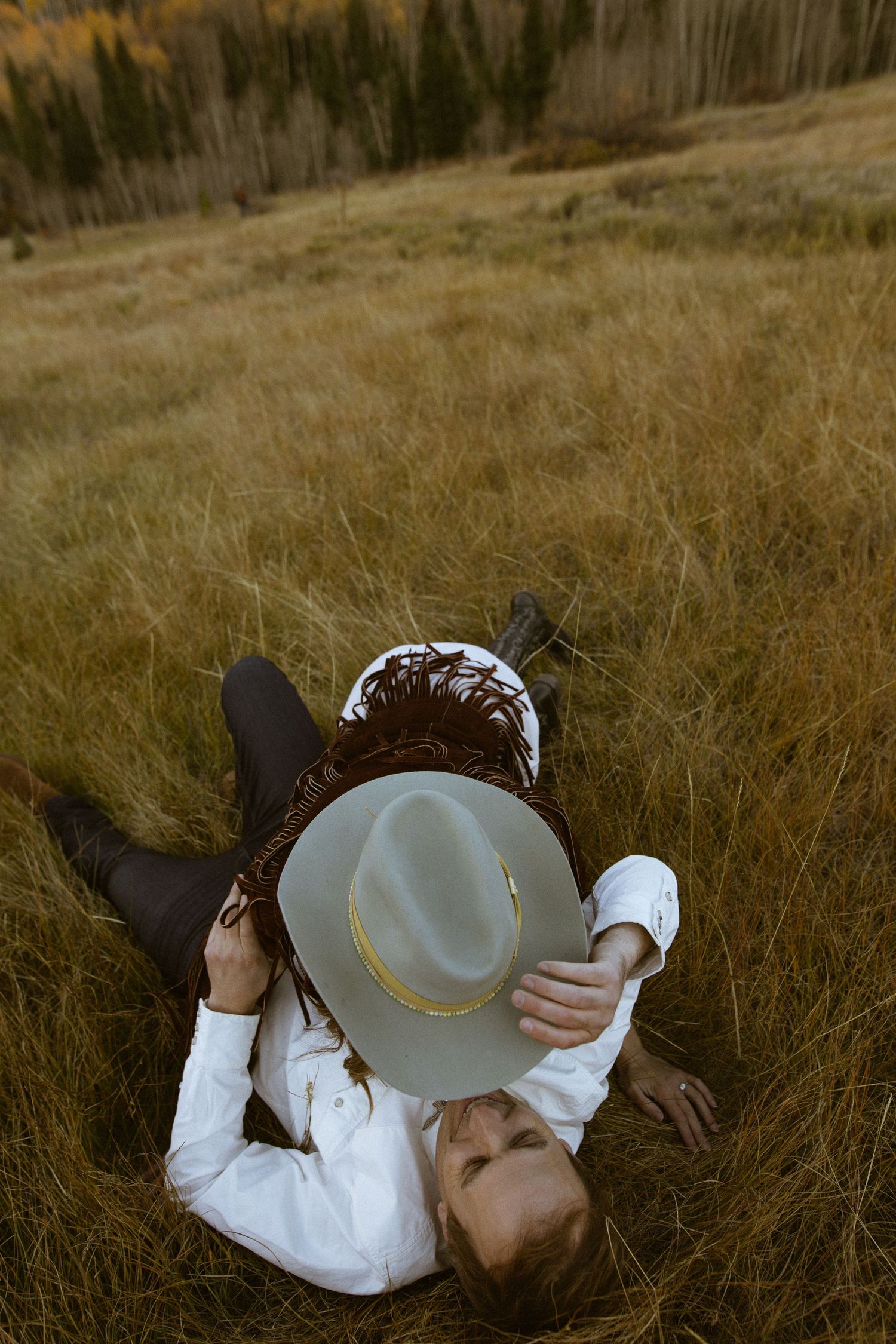 Couple playfully wrestling at Ashcroft Ghost Town Aspen Colorado engagement session by Sammy Aucella Photography