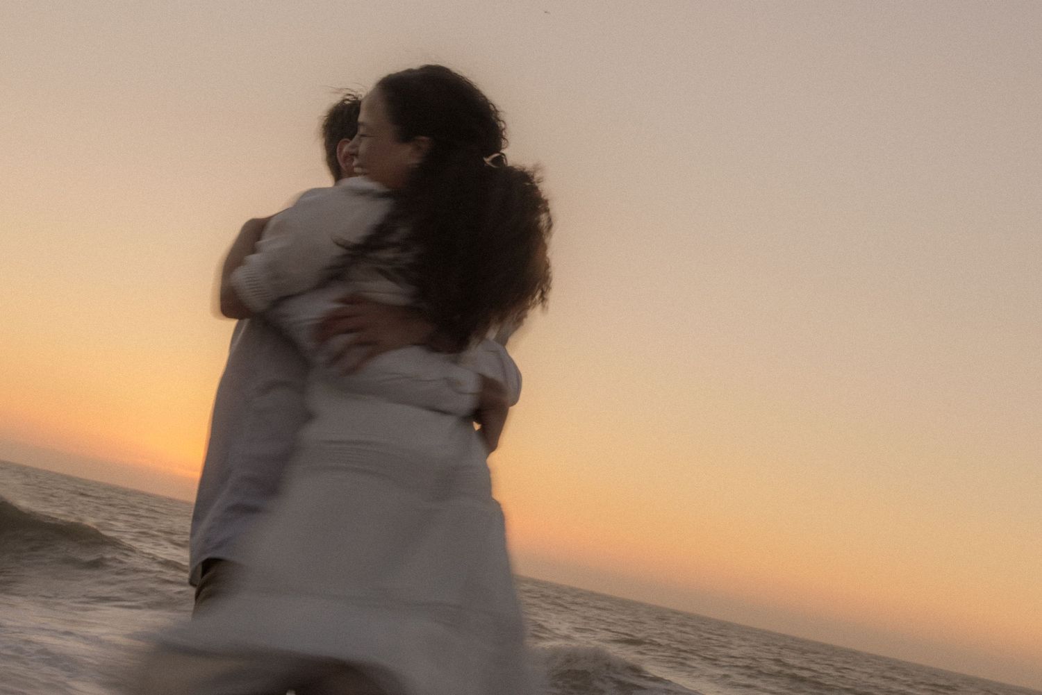 Couple embracing in the ocean water on beach during romantic engagement session in Gualala California Mendocino CA by Sammy Aucella Photogra