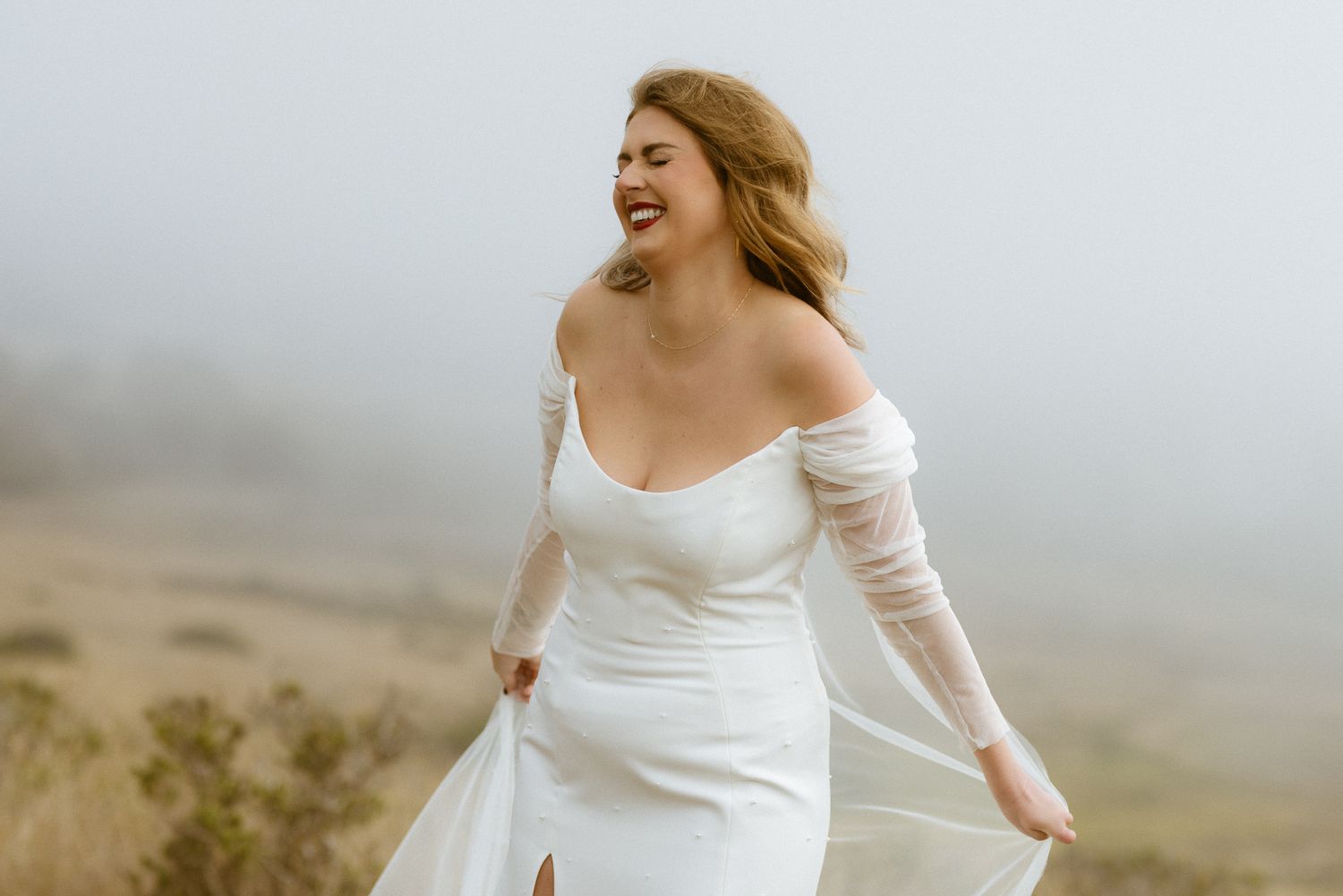 Bride laughing in the coastal fog at a Cuffey's Cove wedding in Elk, Mendocino, California, by Sammy Aucella Photography